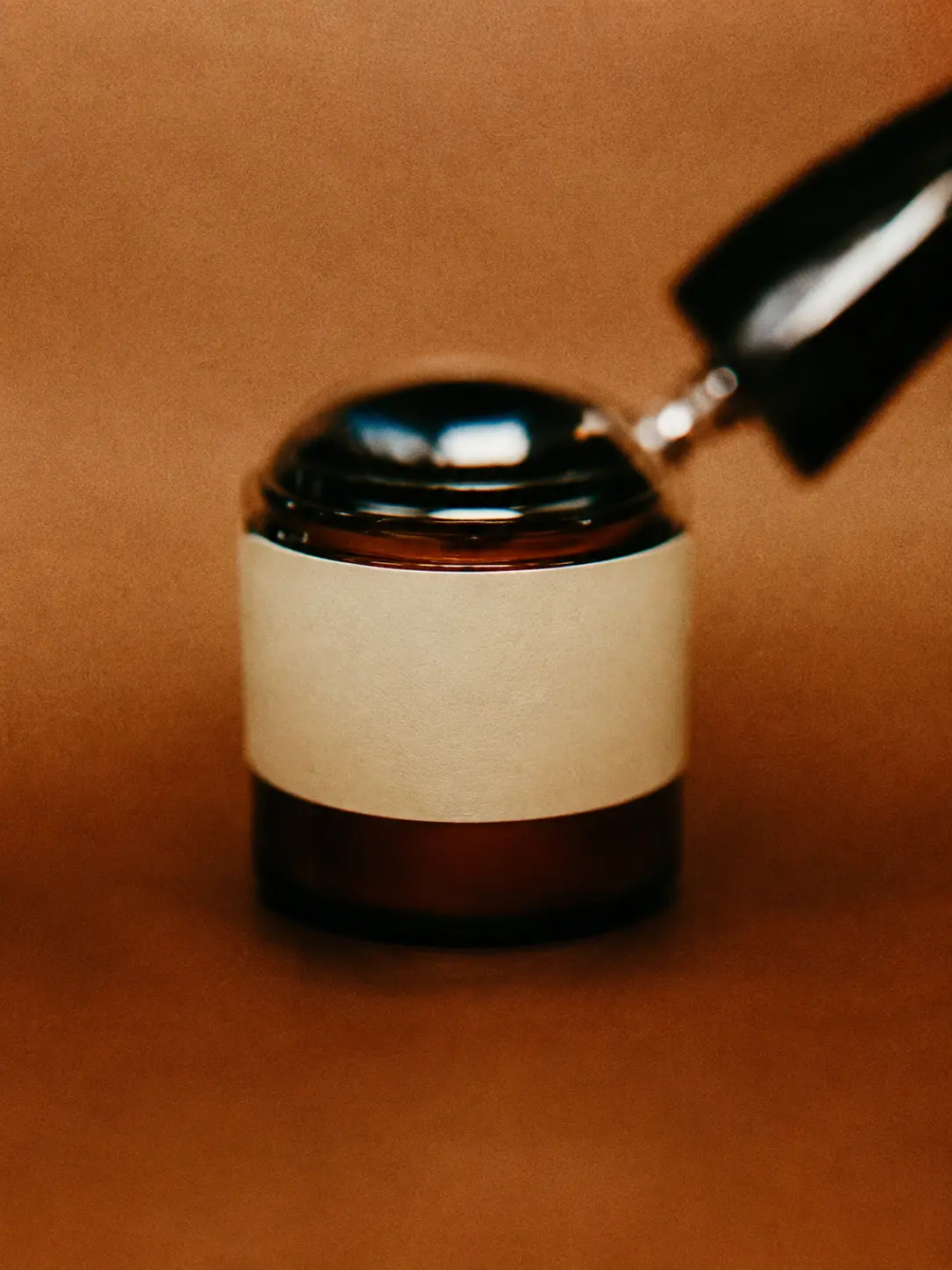 Editorial candle study on a warm amber surface